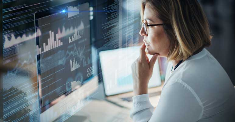 woman looking at data analytics computer image at night