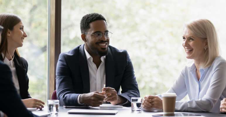 Diverse group of businesspeople sitting around a table in an office.