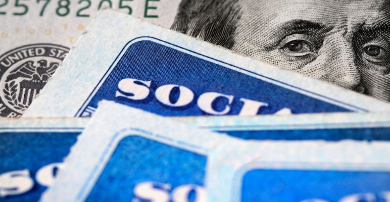 Close-up photograph of a social security card on top of paper money.