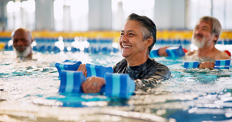 People in pool with dumbbells, hydrotherapy